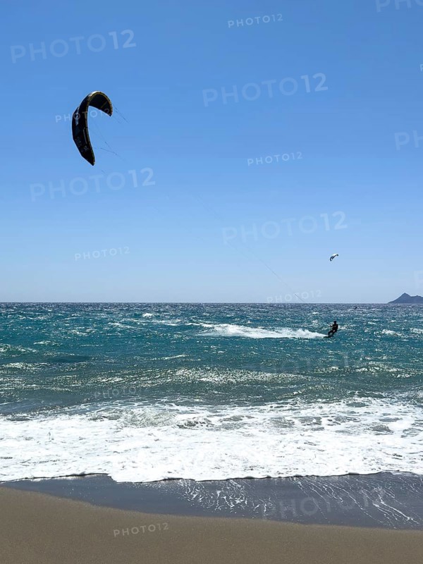 Kitesurfer kite surfer surfing in strong wind and waves rough sea choppy sea with inflated sail, Kalamaki, Crete, Greece, Europe