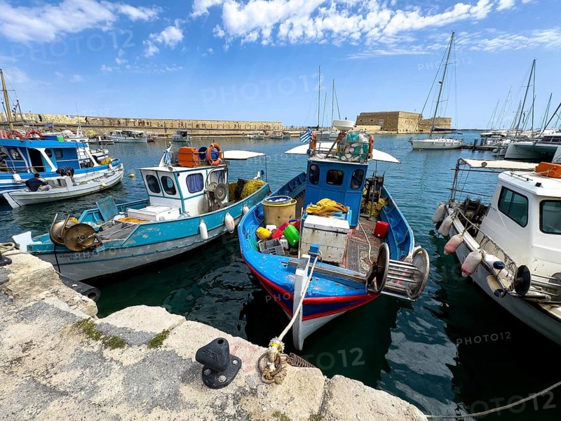 Several small fishing boats in historic Venetian harbour of Heraklion, left in the background historic fortress built in the Middle Ages 16th century by Republic of Venice old name Castello Rocca al Mare today Koules in harbour of Iraklion, Heraklion, Crete, Greece, Europe