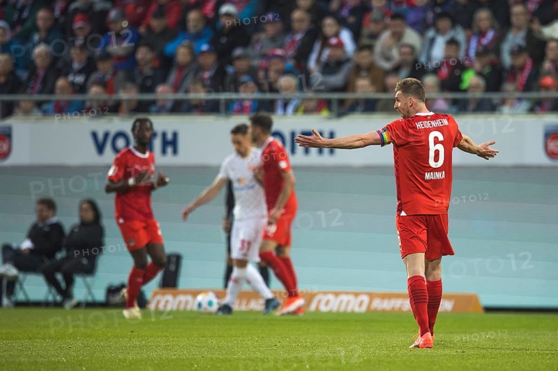 Football match, captain Patrick MAINKA 1.FC Heidenheim right, with outstretched arms and demanding the attention of his team mates, football stadium Voith-Arena, Heidenheim