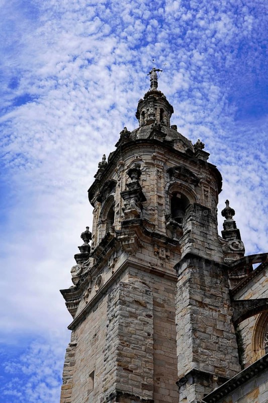 The church Iglesia de San Anton at the river Nervion in Bilbao, Gothic bell tower of a church rising against a cloudy, blue sky, The church Iglesia de San Anton at the river Nervion in Bilbao. Built in 1510, the church is a Catholic place of worship in the old town centre. It is built in the Gothic style with Baroque elements, BILBAO, Spain, Europe