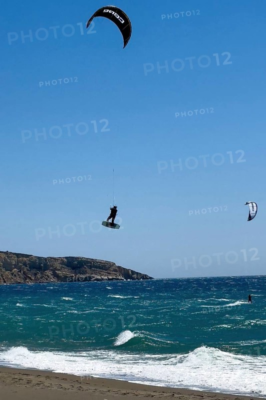 Kitesurfer Kitesurfer takes off in strong wind and waves rough sea moving sea flies with inflated sail through the air, Kalamaki, Crete, Greece, Europe