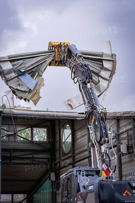 An excavator tears off the roof of a building, debris falls down, demolition, Saarbruecken, Germany, Europe