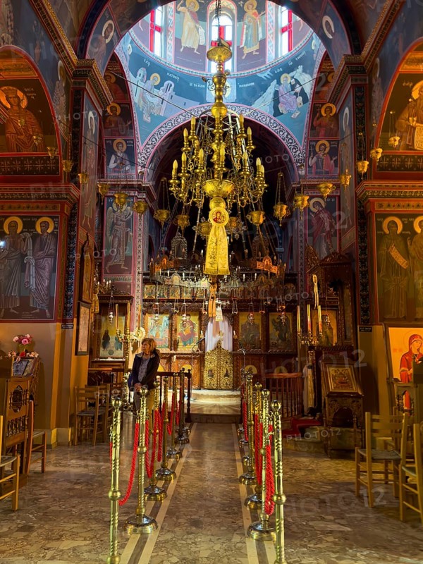 Tourist visiting sanctuary interior of orthodox church with in background chandelier chandelier under dome of monastery church Zoodochos Pege in Byzantine style from 14th century in today's nunnery monastery of Panagia Kalyviani Kaliviani, Faneromeni, Tymbaki, Crete, Greece, Europe