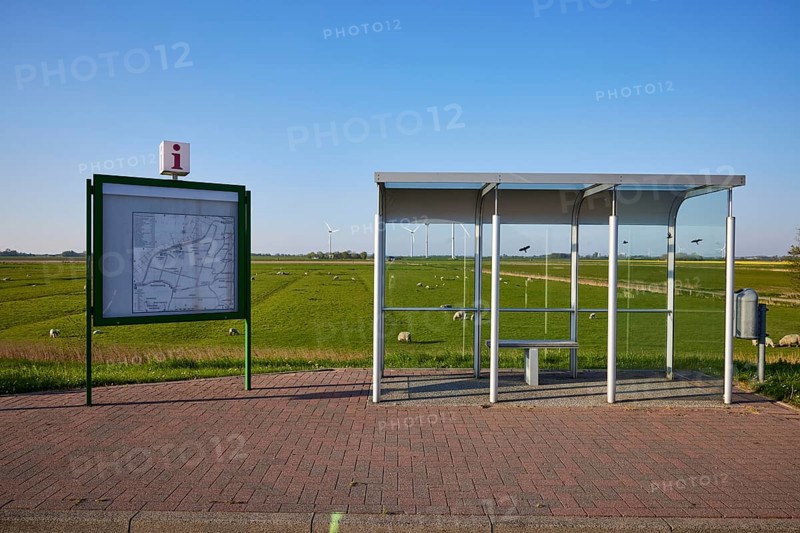 Glass bus shelter at a bus stop and information with road map in the marshland near Simonsberg, Nordfriesland district, Schleswig-Holstein, Germany, Europe