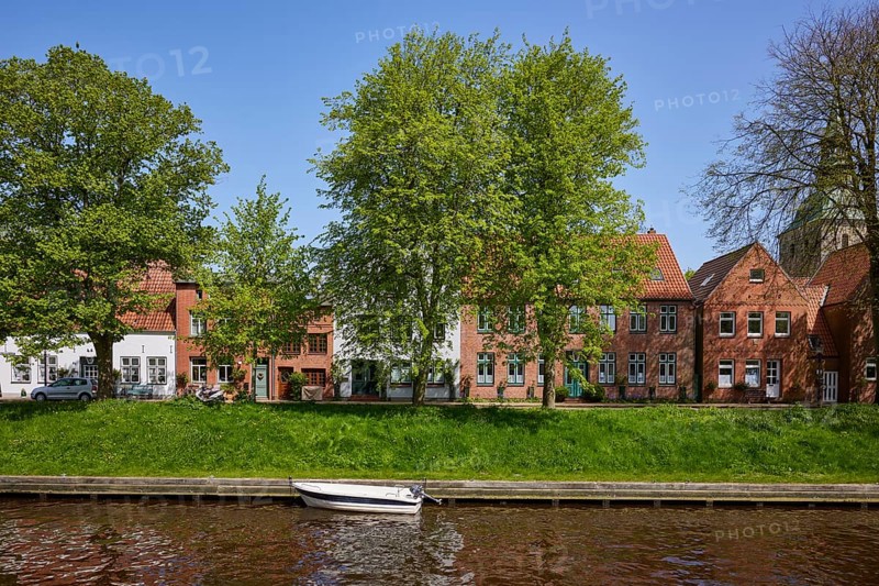 Motorboat on the Mittelburggraben with trees and houses in Friedrichstadt, district of Nordfriesland, Schleswig-Holstein, Germany, Europe