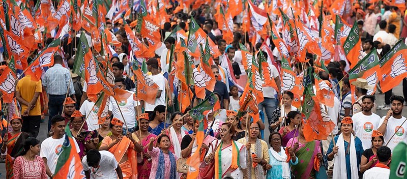 Bharatiya Janata Party (BJP) supporters holding BJP flags arrives to to see a roadshow of Union Home minister Amit Shah, ahead of third phase of General Elections, in Guwahati, Assam, India on 29 April 2024