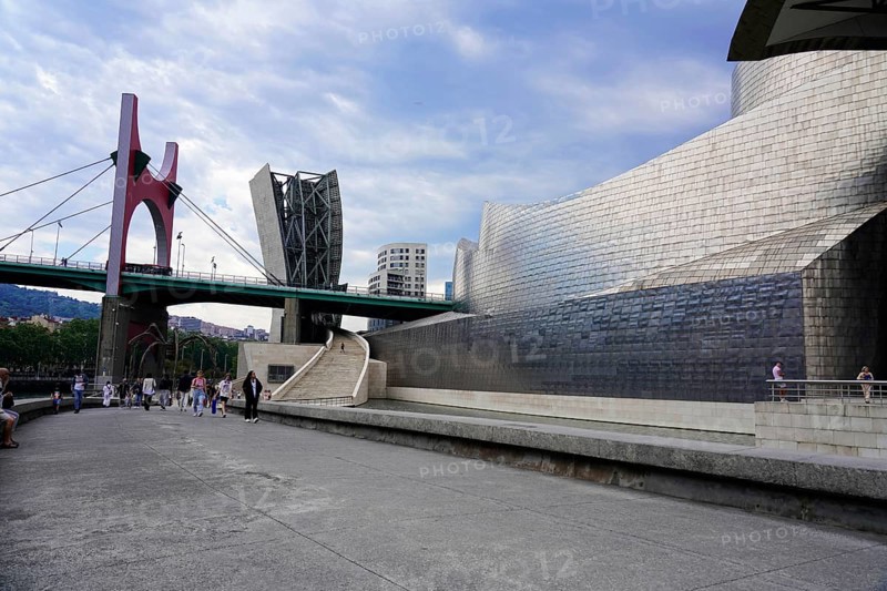Guggenheim Museum Bilbao on the banks of the river Nervion, architect Frank O. Gehry, Bilbao, scene with modern architecture and bridge in an urban environment under a cloudy sky, Guggenheim Museum, architect Frank O. Gehry, Bilbao, province of Bizkaia, Basque Country, Spain, Europe