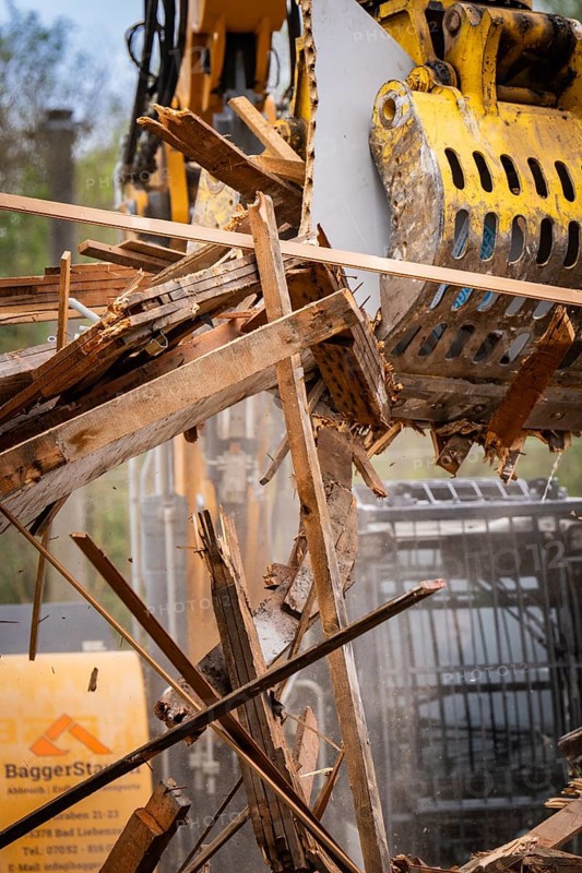 Machine arm of an excavator with hydraulic grab lifting pieces of wood on a construction site, demolition, Saarbruecken, Germany, Europe