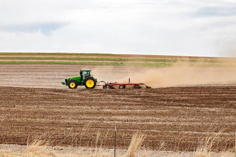 Schaller, Iowa, A cloud of dust blows behind the tractor as a farmer plows his field on a windy day