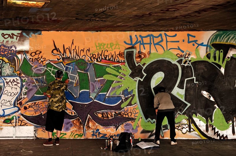 Graffiti artist at work in a skateboard park on the Thames, London, England, Great Britain