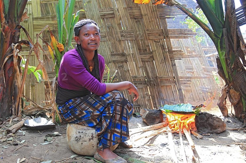South Ethiopia, among the Dorze people, woman bakes flatbread, the mass of the ground false banana is wrapped in a banana leaf after fermentation and baked, Ethiopia, Africa