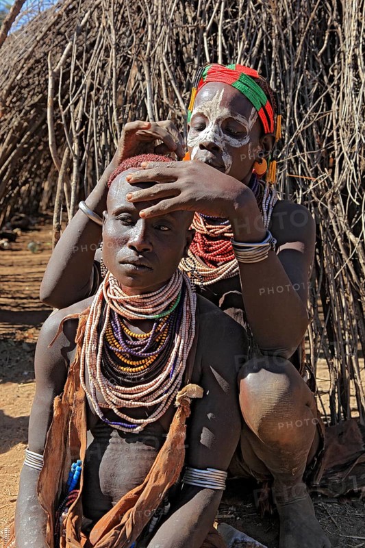 South Ethiopia, Omo region, among the Karo people, woman with jewellery and face painting styling their hair, Ethiopia, Africa