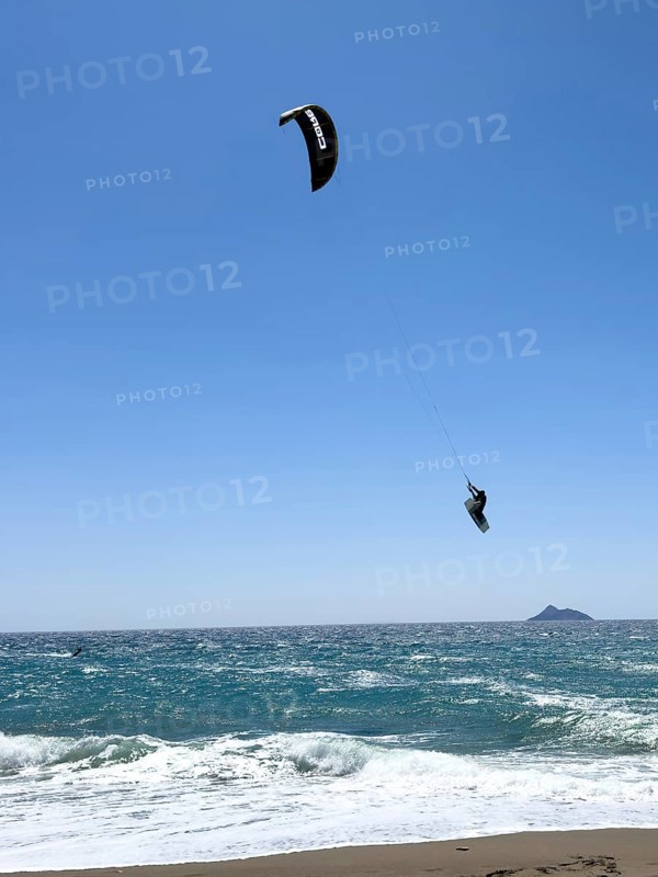 Kitesurfer Kitesurfer takes off in strong wind and waves rough sea moving sea flies with inflated sail through the air, Kalamaki, Crete, Greece, Europe