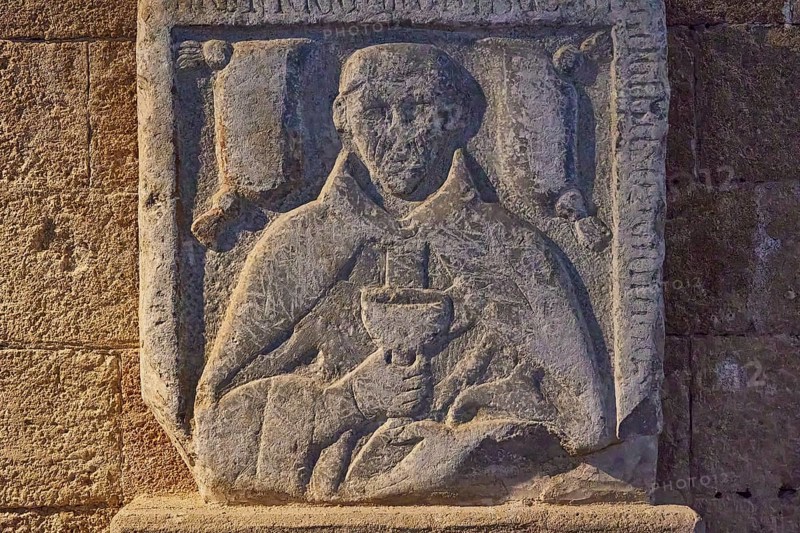 Detail of a stone relief with a drawn monk holding a book, upper part of a tomb slab, outdoor area, Archaeological Museum, Old Town, Rhodes Town, Rhodes, Dodecanese, Greek Islands, Greece, Europe