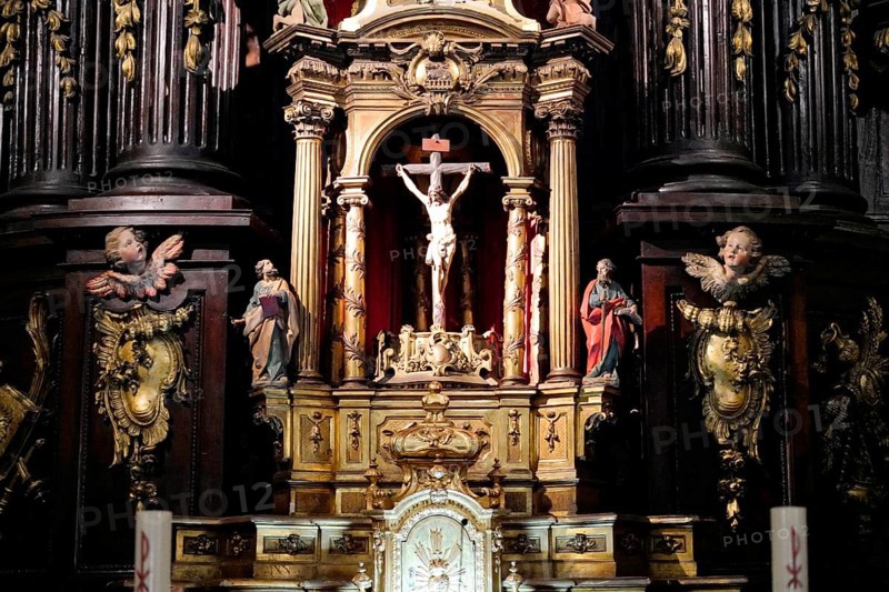 Iglesia San Nicolas de Bari, A richly decorated baroque altar with a crucifix surrounded by figures of saints and ornate decorations in a dark wooden church, Old Town, Bilbao, Basque Country, Spain, Europe