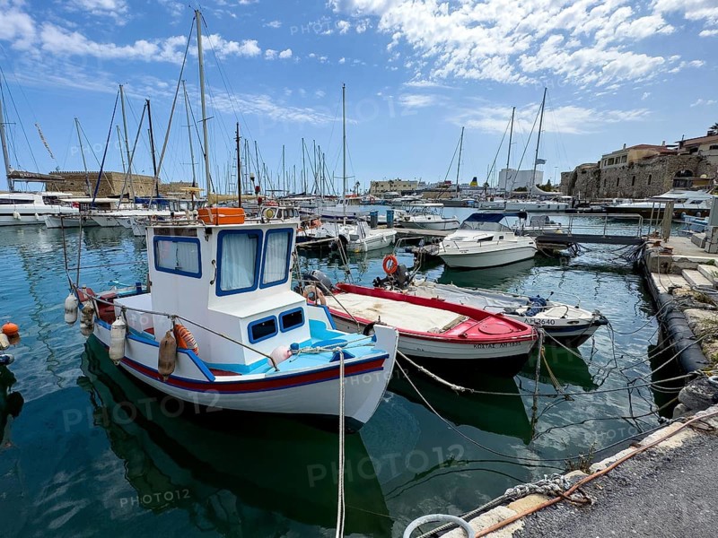 Several small fishing boats in historic Venetian harbour of Heraklion, left in the background historic fortress built in the Middle Ages 16th century by Republic of Venice old name Castello Rocca al Mare today Koules in harbour of Iraklion, Heraklion, Crete, Greece, Europe