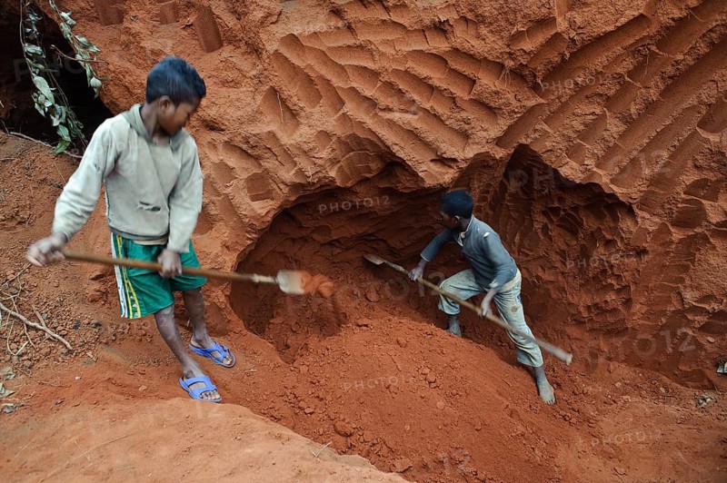 Boys working to collect soil, soil is used as an outside coating for the walls of the houses, Ambositra, Madagascar. boys from the Betsileo ethnic group