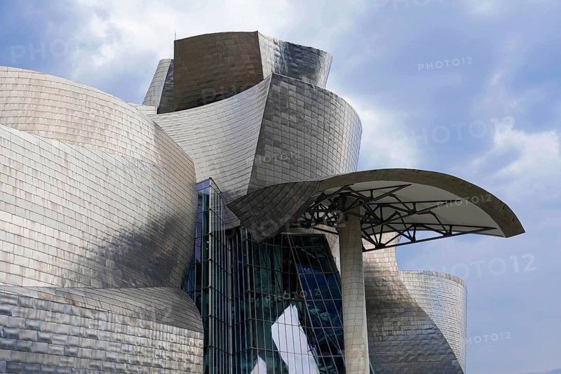 Guggenheim Museum Bilbao on the banks of the river Nervion, architect Frank O. Gehry, Bilbao, detailed view of the modern art museum, structured metal panelling and glass fronts under a cloudy sky, Guggenheim Museum, architect Frank O. Gehry, Bilbao, province of Bizkaia, Basque Country, Spain, Europe