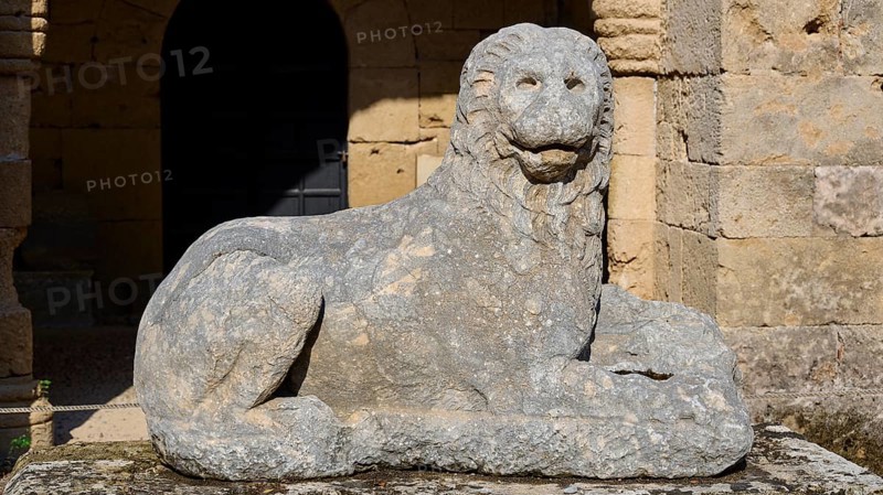 Stone lion statue sits majestically in front of a medieval fortress, outdoor area, Archaeological Museum, Old Town, Rhodes Town, Rhodes, Dodecanese, Greek Islands, Greece, Europe