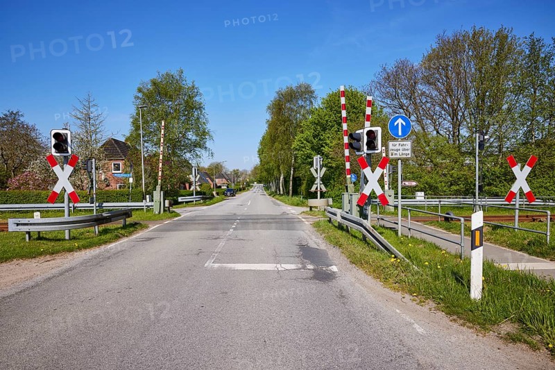 Gated level crossing with St Andrew's crosses and traffic lights for motor vehicles in Niebuell, Nordfriesland district, Schleswig-Holstein, Germany, Europe