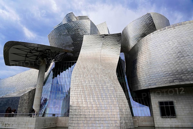 Guggenheim Museum Bilbao, Spain, Europe, The image shows an imposing metal structure with undulating surfaces under a dramatic sky, Guggenheim Museum Bilbao on the banks of the river Nervion, architect Frank O. Gehry, Bilbao, Basque Country, Europe