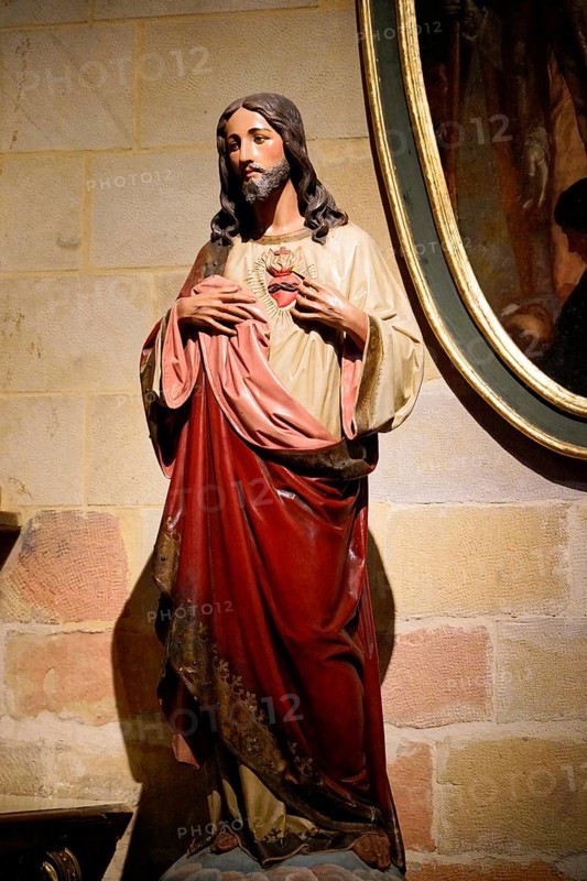 The Iglesia de San Anton church on the Nervion river in Bilbao, A statue of Jesus showing the heart in front of a stone wall in a church, The Iglesia de San Anton church on the Nervion river in Bilbao. Built in 1510, the church is a Catholic place of worship in the historic centre. It is built in the Gothic style with Baroque elements, BILBAO, Spain, Europe