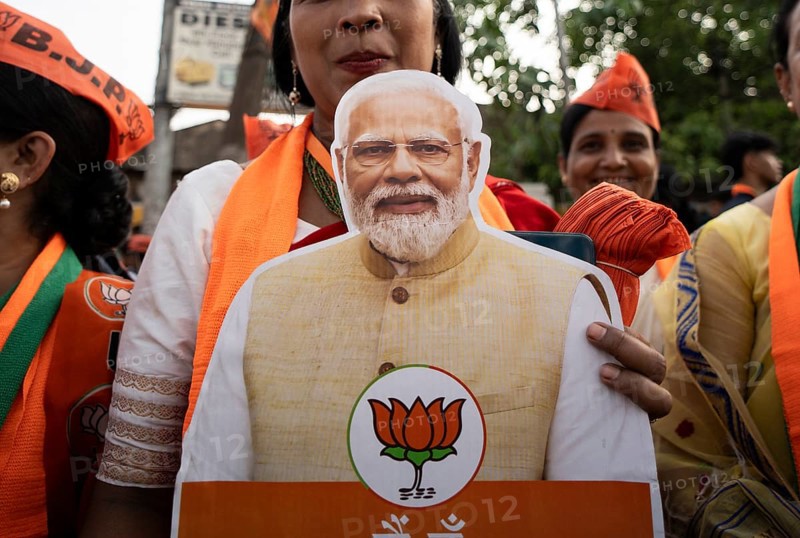 Bharatiya Janata Party (BJP) supporters holds a cutout of Narendra Modi as they arrives to to see a roadshow of Union Home minister Amit Shah, ahead of third phase of General Elections, in Guwahati, Assam, India on 29 April 2024