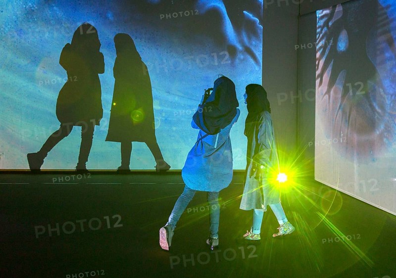 Two woman look at an exhibition by the German artist Otto Piene in Tehran on 6 April 2015 and make shadow plays in the light installation, Tehran, Iran, Asia