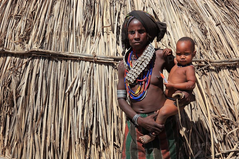 South Ethiopia, in a village of the Arbore or Erbore people at Lake Stefano, young woman with baby in front of her hut, Ethiopia, Africa