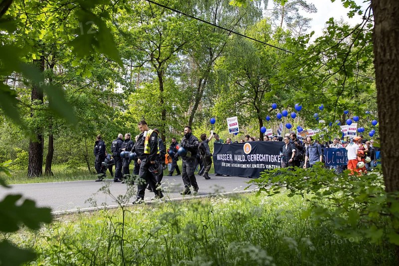 Participants with banner Water. Forest. Justice. For a traffic turnaround beyond Tesla and balloons on the L23 road at the demonstration Wasser. Justice against the expansion of the Tesla Gigafactory in Gruenheide near Berlin, 11 May 2024