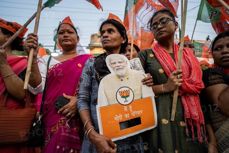 Bharatiya Janata Party (BJP) supporters holds a cutout of Narendra Modi as they arrives to to see a roadshow of Union Home minister Amit Shah, ahead of third phase of General Elections, in Guwahati, Assam, India on 29 April 2024