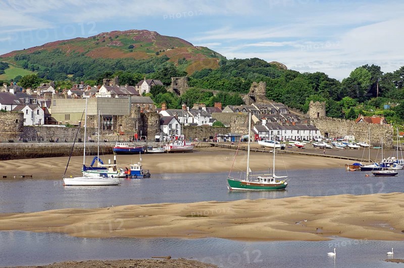 Small harbour at low tide with sailing ships, parts of an old fortification, Conwy, Wales, Great Britain