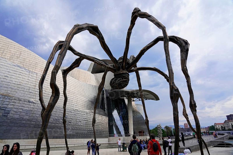 Guggenheim Museum Bilbao on the banks of the river Nervion, Architect Frank O. Gehry, Bilbao, A huge spider sculpture in front of a modern art museum. People stand around the sculpture and marvel at the architecture, Guggenheim Museum, Architect Frank O. Gehry, Bilbao, Province of Bizkaia, Basque Country, Spain, Europe