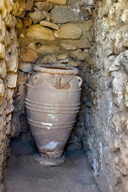 View into historical storeroom below present floor level with large decorated clay vessel Pithoi in ancient magazine building with supplies in excavation site on hill of Phaistos palace of Minoan culture pre-Greek ancient Greek people Minoans in antiquity, Kamilari, Crete, Greece, Europe