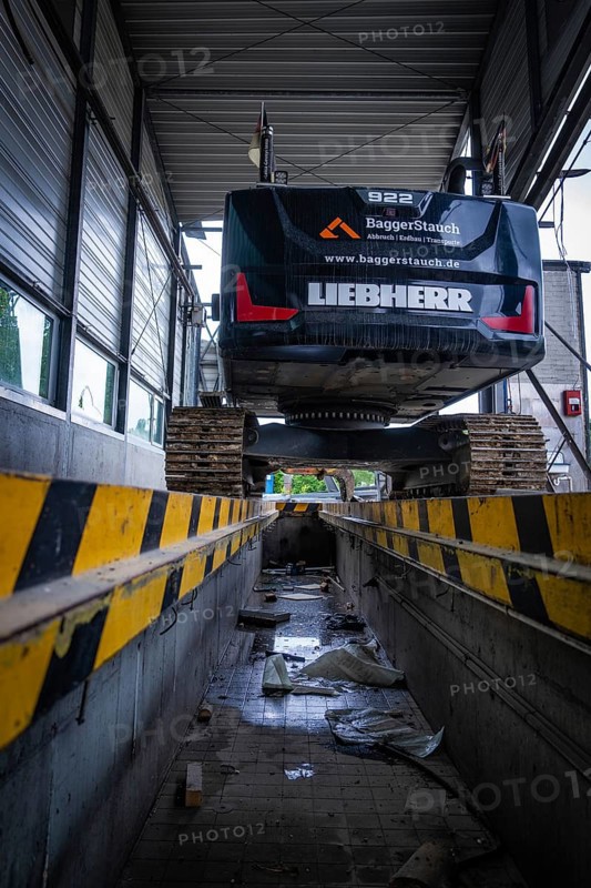 An excavator stands on a lifting platform inside a building, demolition, Saarbruecken, Germany, Europe