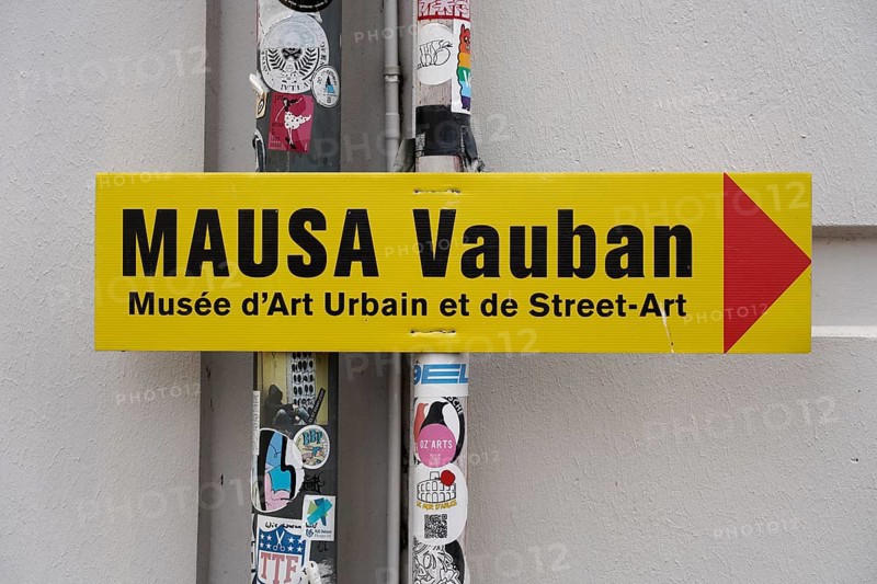 MAUSA VAUBAN, Museum of Urban Art and Street Art, Neuf-Brisach Fortress, France, Europe, Yellow sign pointing to the MAUSA Vauban Museum, surrounded by stickers, Europe