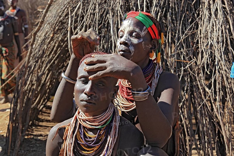 South Ethiopia, Omo region, among the Karo people, woman with jewellery and face painting styling their hair, Ethiopia, Africa