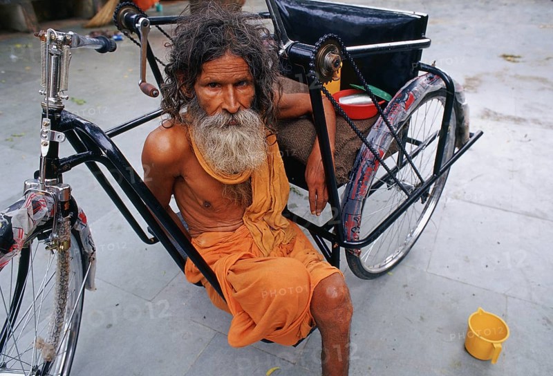 Amputee with the wheelchair he received from a charity, beggar dressed like a hindu ascetic, Jaipur, India, Asia