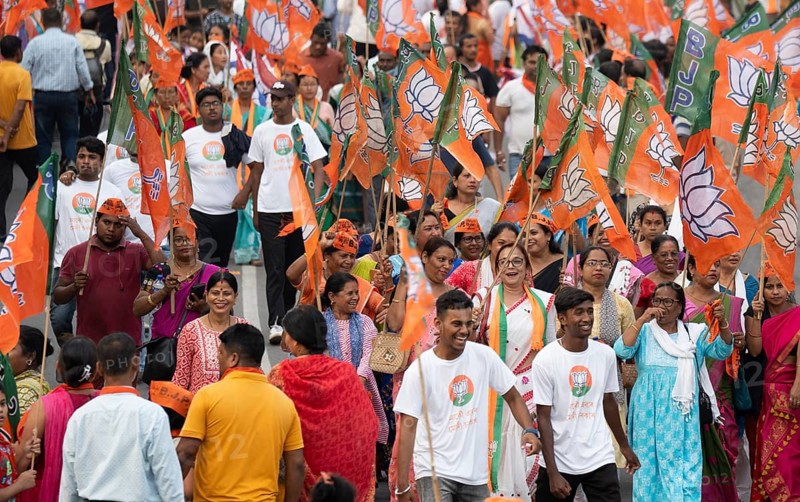 Bharatiya Janata Party (BJP) supporters holding BJP flags arrives to to see a roadshow of Union Home minister Amit Shah, ahead of third phase of General Elections, in Guwahati, Assam, India on 29 April 2024