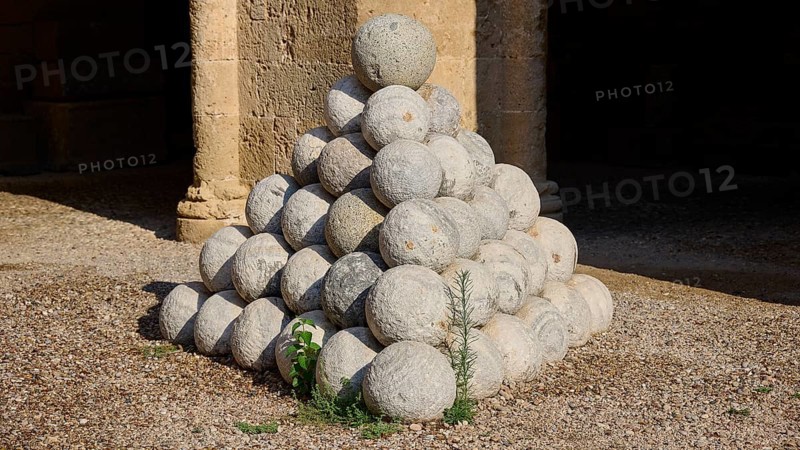 Large pyramid of stone cannonballs on a gravel floor, outdoor area, Archaeological Museum, Old Town, Rhodes Town, Rhodes, Dodecanese, Greek Islands, Greece, Europe