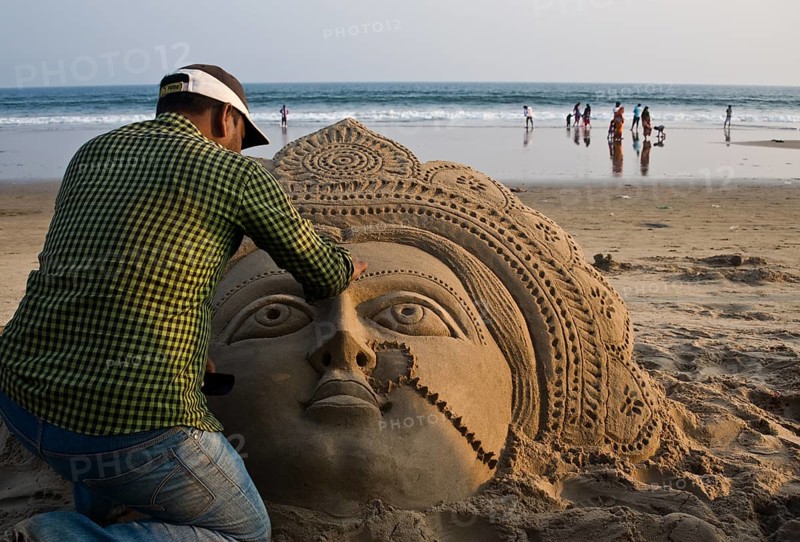 Sand artist sculpting a sand sculpture, sculpture representing the hindu goddess Lakshmi, beach at Puri, India, Asia