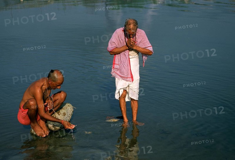 High caste hindu men performing a ritual, worshiing the sun god in the Gandaki river, Nepal, Asia