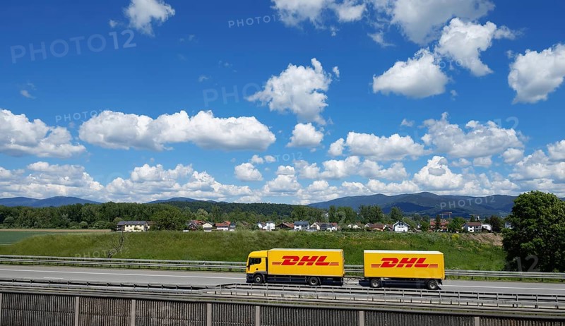 A DHL lorry drives past Deggendorf on the A3 motorway, with the Bavarian Forest in the background, Bavaria, Germany, Europe