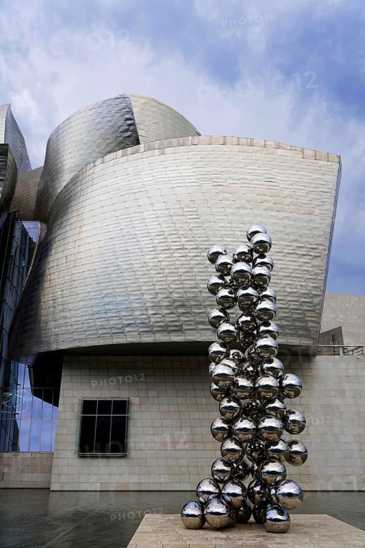 Guggenheim Museum Bilbao, Spain, Europe, The picture shows a modern sculpture made of metal spheres in front of an impressive, wave-shaped building, Guggenheim Museum Bilbao on the banks of the river Nervion, architect Frank O. Gehry, Bilbao, Basque Country, Europe