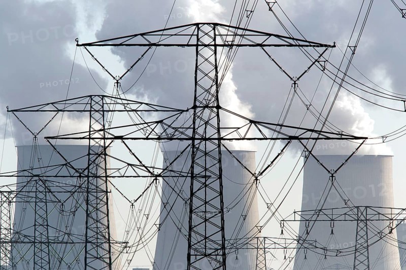 Steam rises from the cooling towers of the Vattenfall power plant in Jaenschwalde, power lines and electricity pylons at the power plant on 9 December 2014. The energy company Vattenfall mines lignite to generate electricity in the surrounding opencast mines in Brandenburg, Jaenschwalde, Germany, Europe