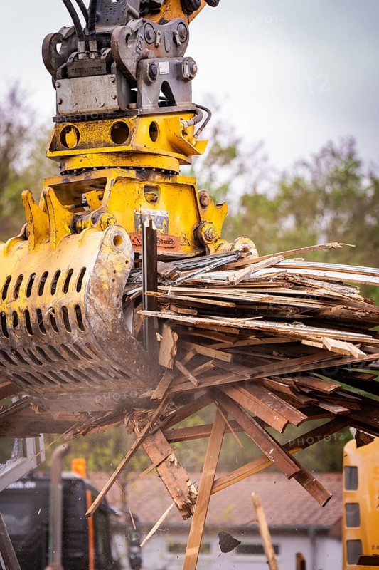 A hydraulic grab on an excavator grabs wood waste on a construction site, demolition, Saarbruecken, Germany, Europe