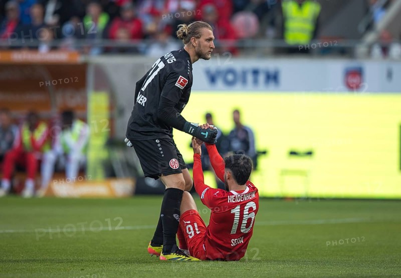 Football match, The exhausted Kevin SESSA 1. FC Heidenheim right, still sitting on the pitch, is pulled up from the ground by goalkeeper Robin ZENTNER 1. FSV Mainz 05, football stadium Voith-Arena, Heidenheim