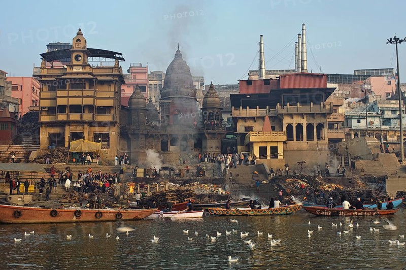 Manikarnika ghat, the main cremation ground in Varanasi, India. Ganges river and gulls in the foreground. Varanasi is the main pilgrimage site for hindus