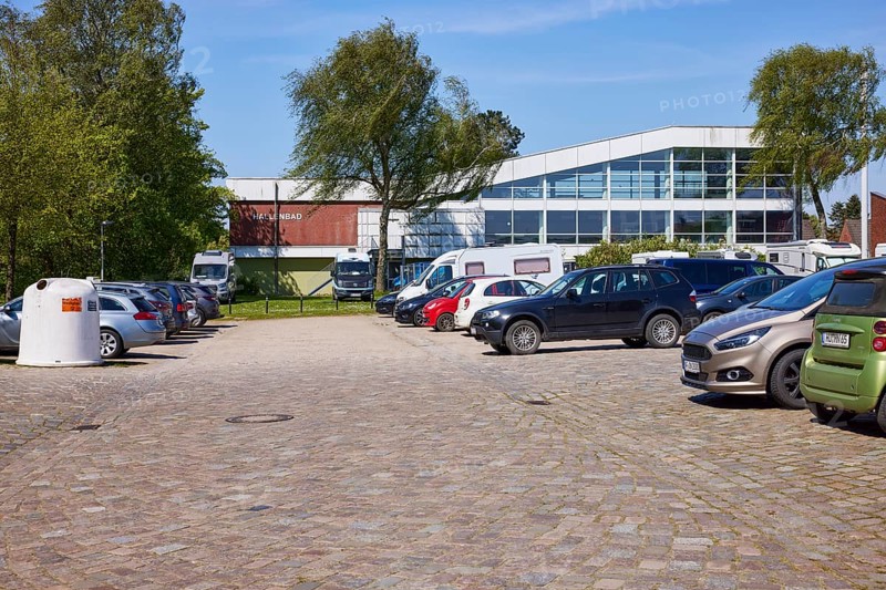 Used glass container, car park and indoor swimming pool in Niebuell, Nordfriesland district, Schleswig-Holstein, Germany, Europe
