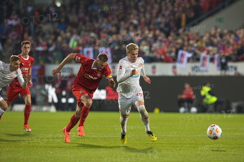 Football match, captain Patrick MAINKA 1. FC Heidenheim left seems to sprint past opponent Jonathan Michael BURKARDT 1. FSV Mainz 05 to get to the ball in front of him, Jan SCHOePPNER 1. FC Heidenheim in the background, Voith-Arena football stadium, Heidenheim
